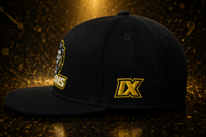 Side view of the black IX Lions snapback hat showing the embroidered gold IX logo